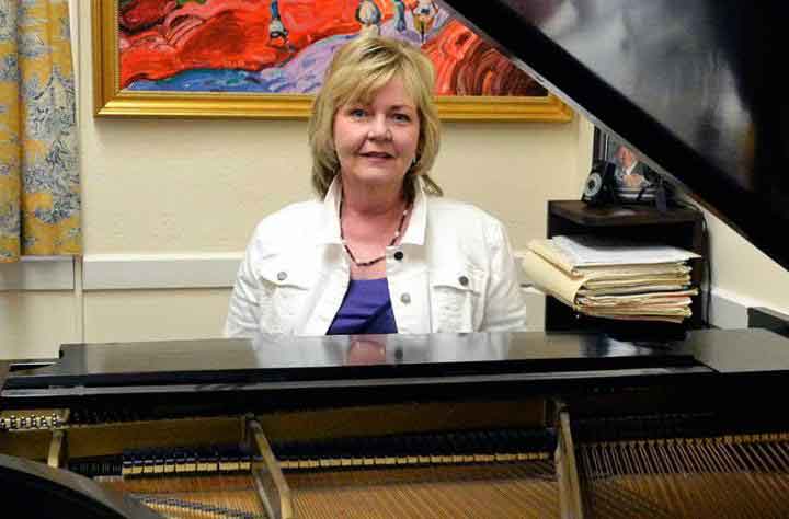 Faculty member Ellen Hanson sits at her piano in her office
