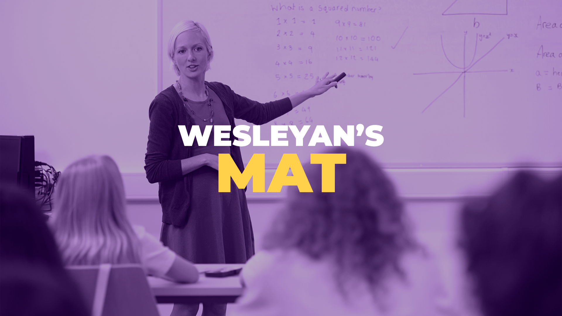 MAT Photo A female teaching pointing to a whiteboard while teaching a class