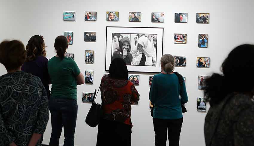 Group of Women look at images in the Iran Women exhibition.